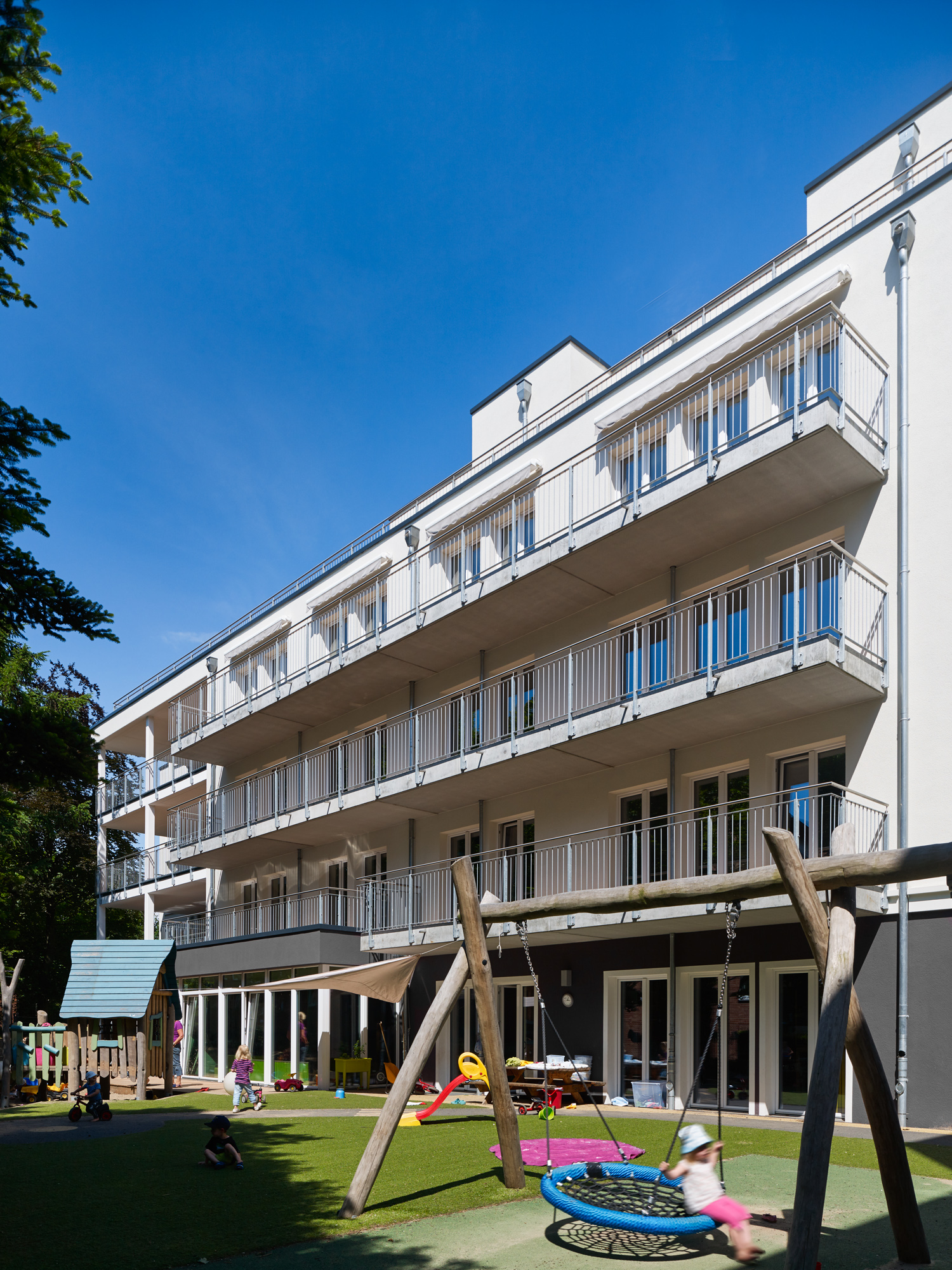 Haus Fahrenkrön in Hamburg: Altenzentrum mit Kitas, Balkonfassade und Spielbereich im Innenhof.